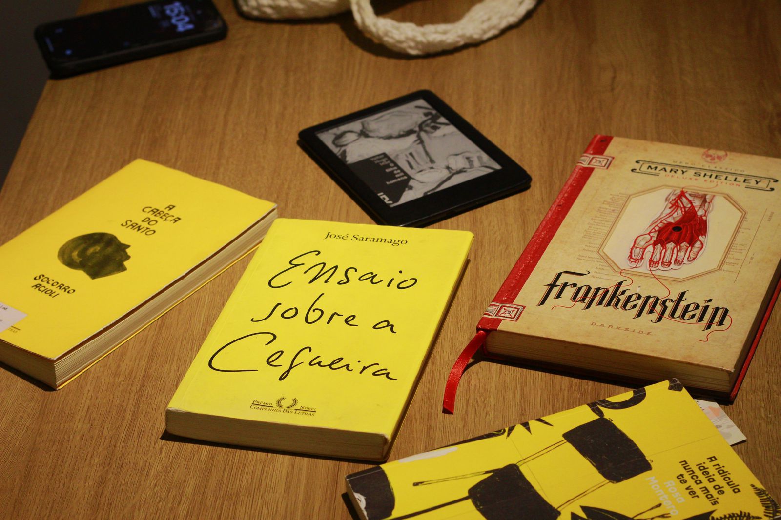 Mãos segurando um livro aberto ao lado de um caderno